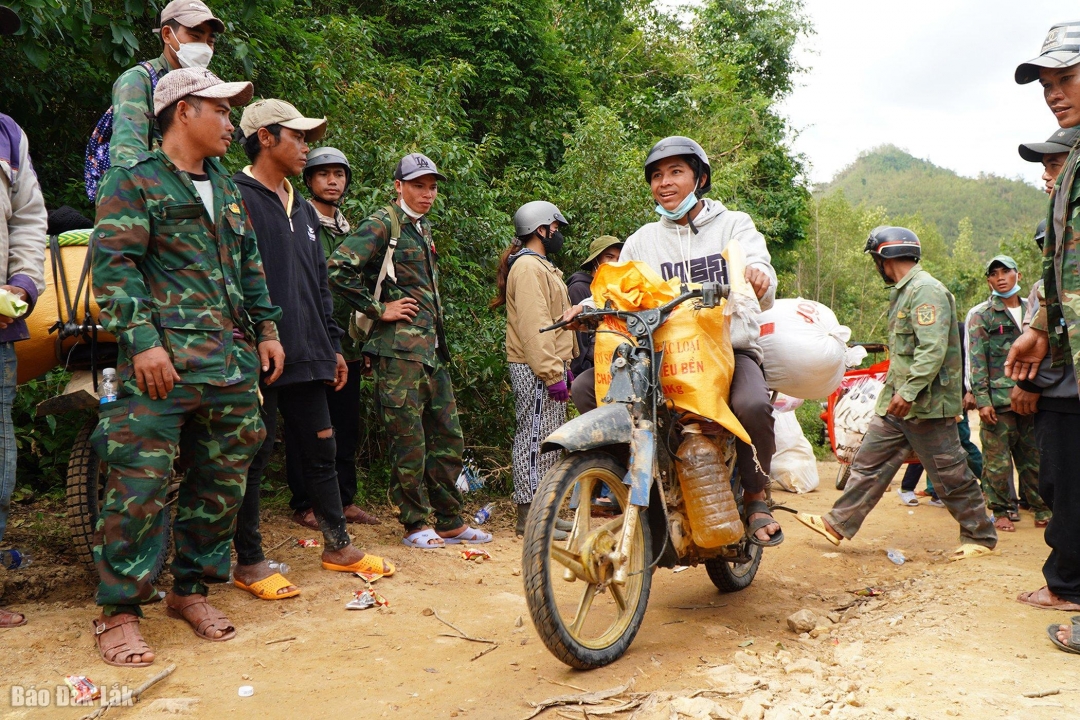 Niềm vui của một người dân khi vượt qua đoạn đường hiểm trở để mang hàng cứu trợ về thôn. 