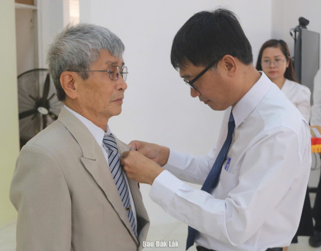 Bí thư Đảng ủy, Chủ tịch HĐND phường Phú Yên Trần Xuân Túc gắn Huy hiệu 60 năm tuổi Đảng chi đảng viên Huỳnh Lữ Sinh.