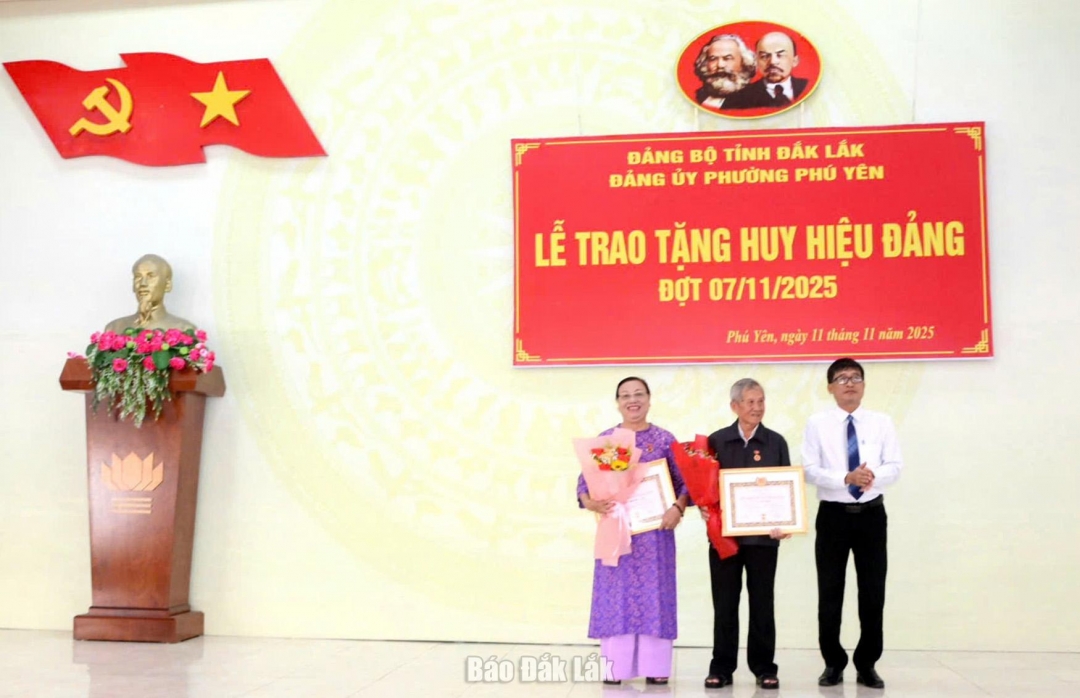 Bí thư Đảng ủy, Chủ tịch HĐND phường Phú Yên Trần Xuân Túc trao Huy hiệu 55 năm tuổi Đảng cho đảng viên.