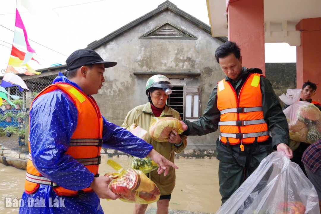 Bộ đội trao những phần nhu yếu phẩm cho người dân vùng lũ