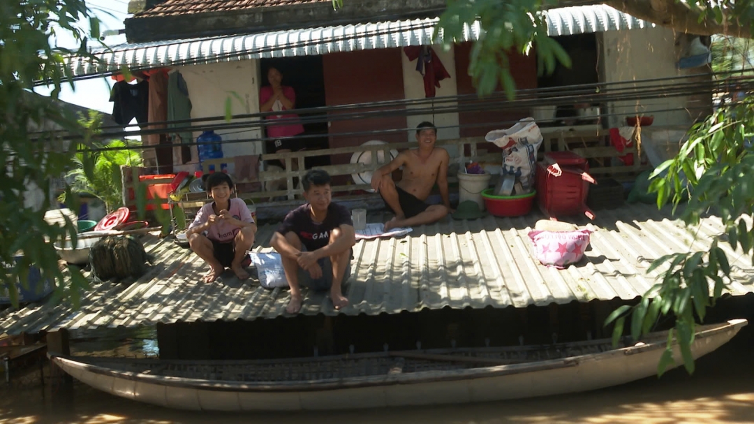 Nước lũ dâng cao, nhiều người dân ở xã ĐỒng Xuân, Tuy An Bắc phải lên mái nhà tránh lũ, chờ nước rút. Ảnh: Thùy Thảo