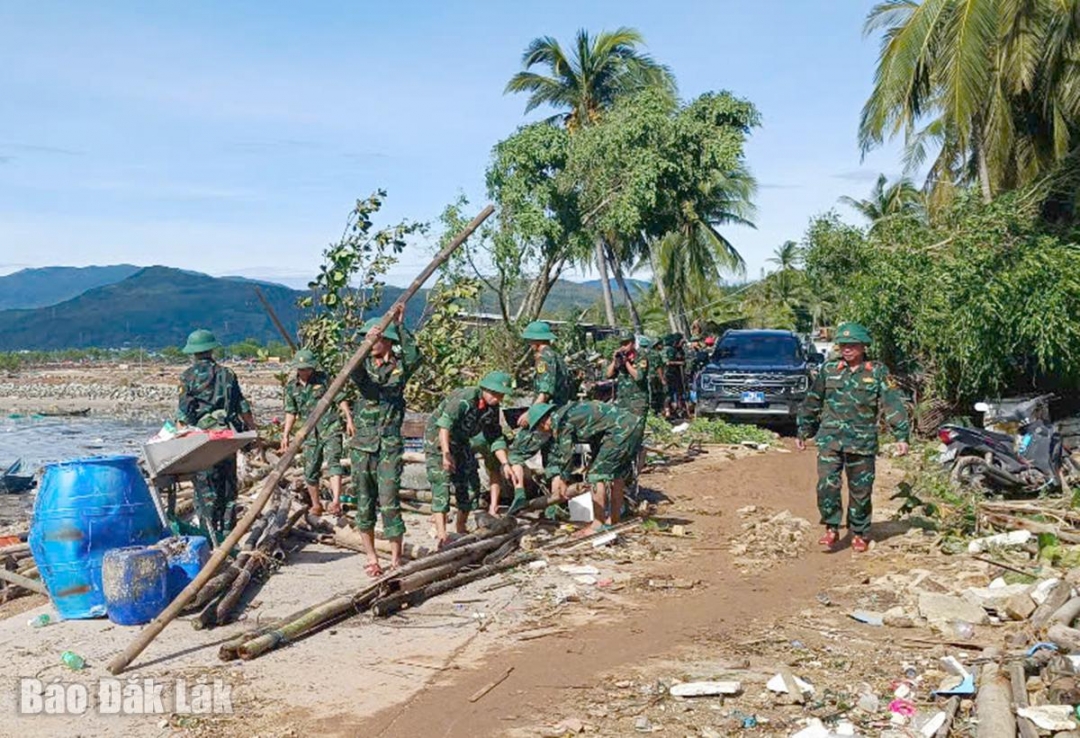 Lực lượng quân sự hỗ trợ thu dọn các thiệt hại sau bão tại phường Sông Cầu.