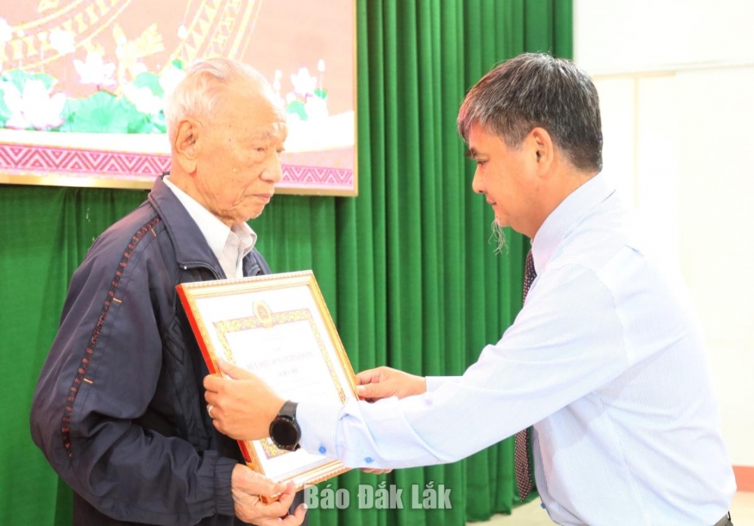 Bí thư Đảng ủy, Chủ tịch HĐND phường Tân An Nguyễn Đức Vinh trao Huy hiệu 65 năm tuổi Đảng cho đảng viên Lê Đức Phú.