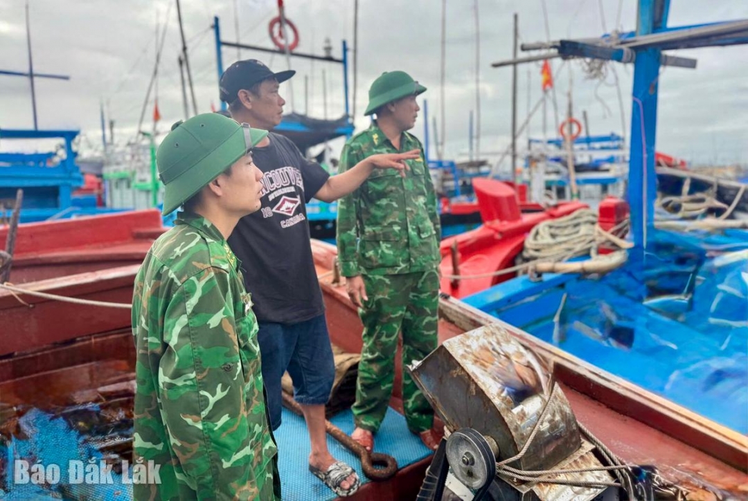 Cán bộ, chiến sĩ Đồn Biên phòng Tuy Hòa vận động, hướng dẫn ngư dân đưa tàu cá vào nơi neo đậu an toàn.