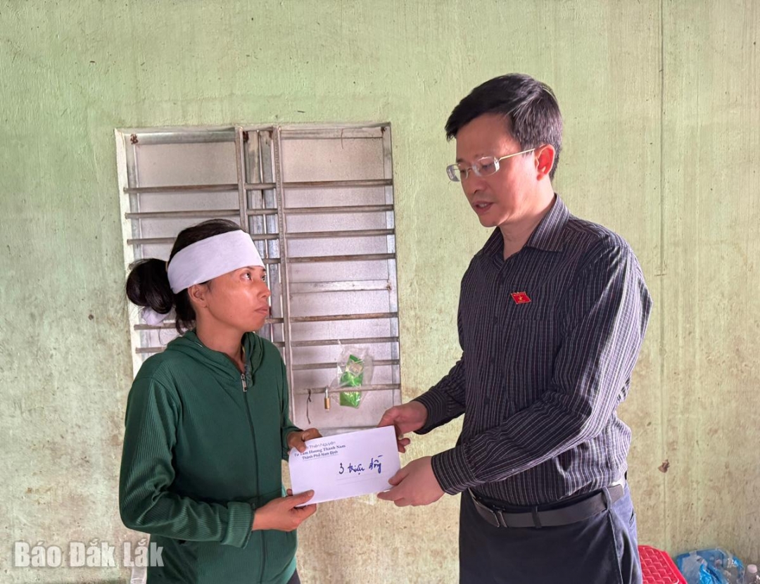 Đại biểu quốc hội Đỗ Chí Nghĩa thăm một trường hợp gia đình có người mất do lũ tại xã Hòa Thịnh.