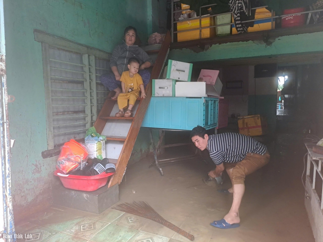 Người dân tranh thủ dọn nhà cửa khi nước đang rút dần.