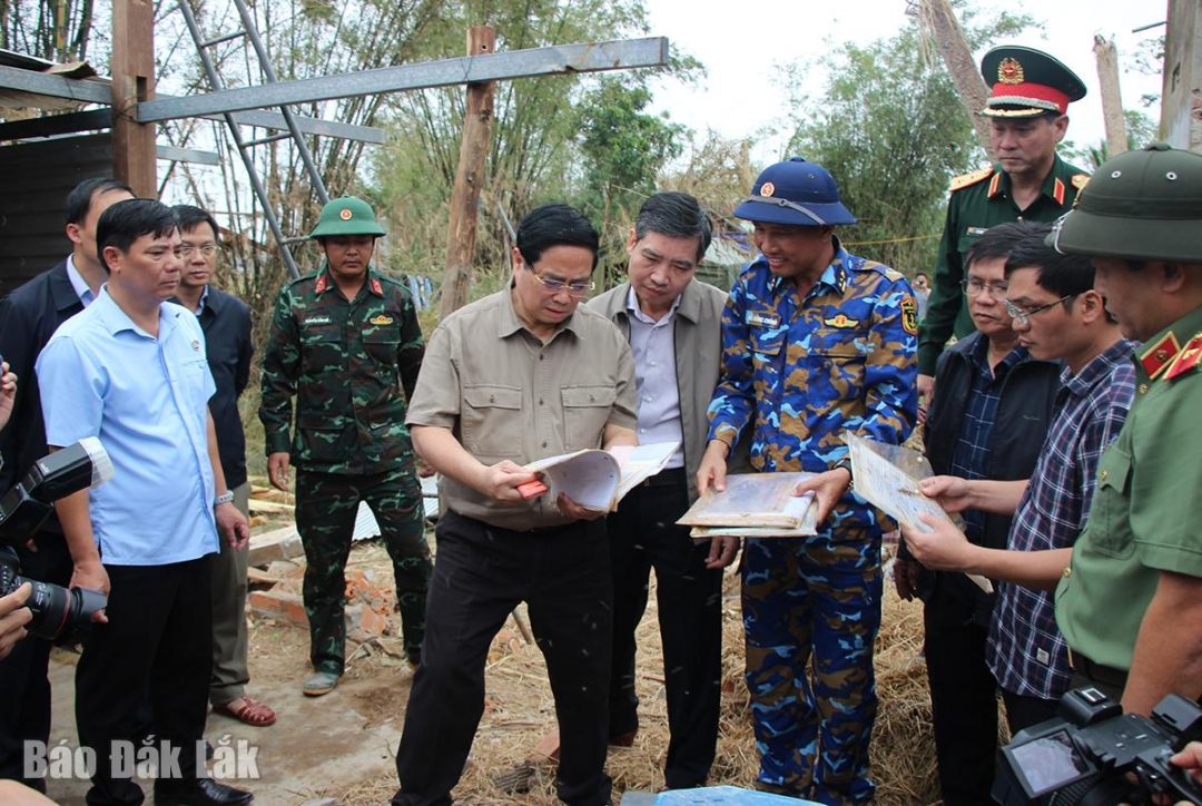Thủ tướng Chính phủ Phạm Minh Chính tìm thấy sách vở, giấy tờ của người dân bị vùi trong đống đổ nát. Ảnh: H.Như