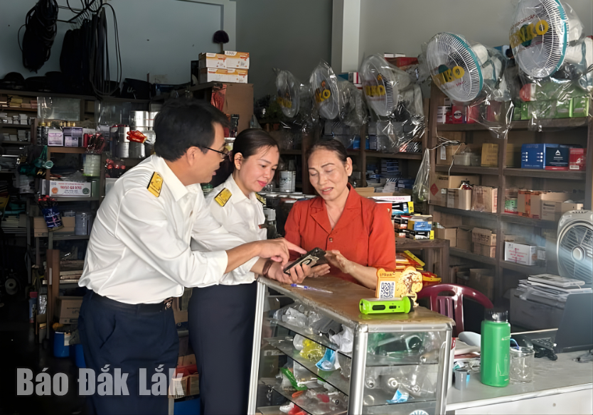 Cán bộ Thuế cơ sở 9 tỉnh Đắk Lắk tuyên truyền, hướng dẫn hộ kinh doanh chuyển đổi mô hình hoạt động.