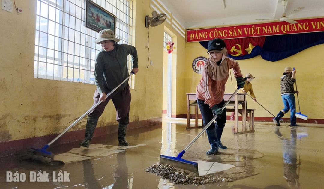 Cán bộ, giáo viên Trường tiểu học và THCS Xuân Sơn Bắc dội rửa bùn, đất ở trường bị ngập để cho học sinh đi học lại.