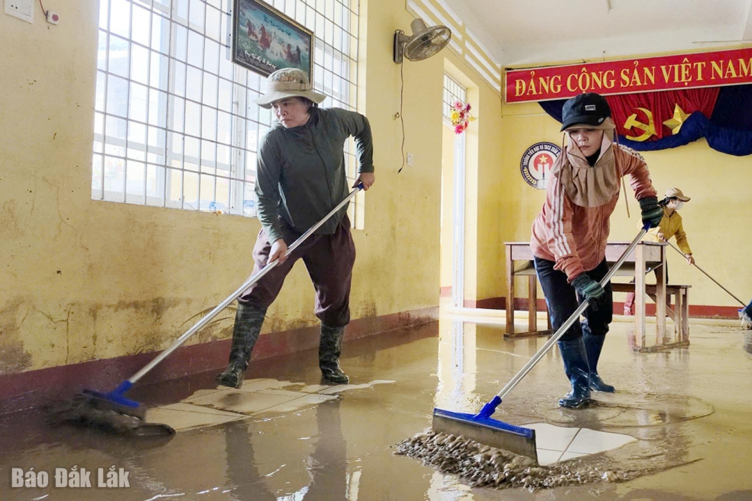 Giáo viên Trường Tiểu học & THCS Xuân Sơn Bắc đẩy lớp bùn dày ra ngoài để vệ sinh lớp.