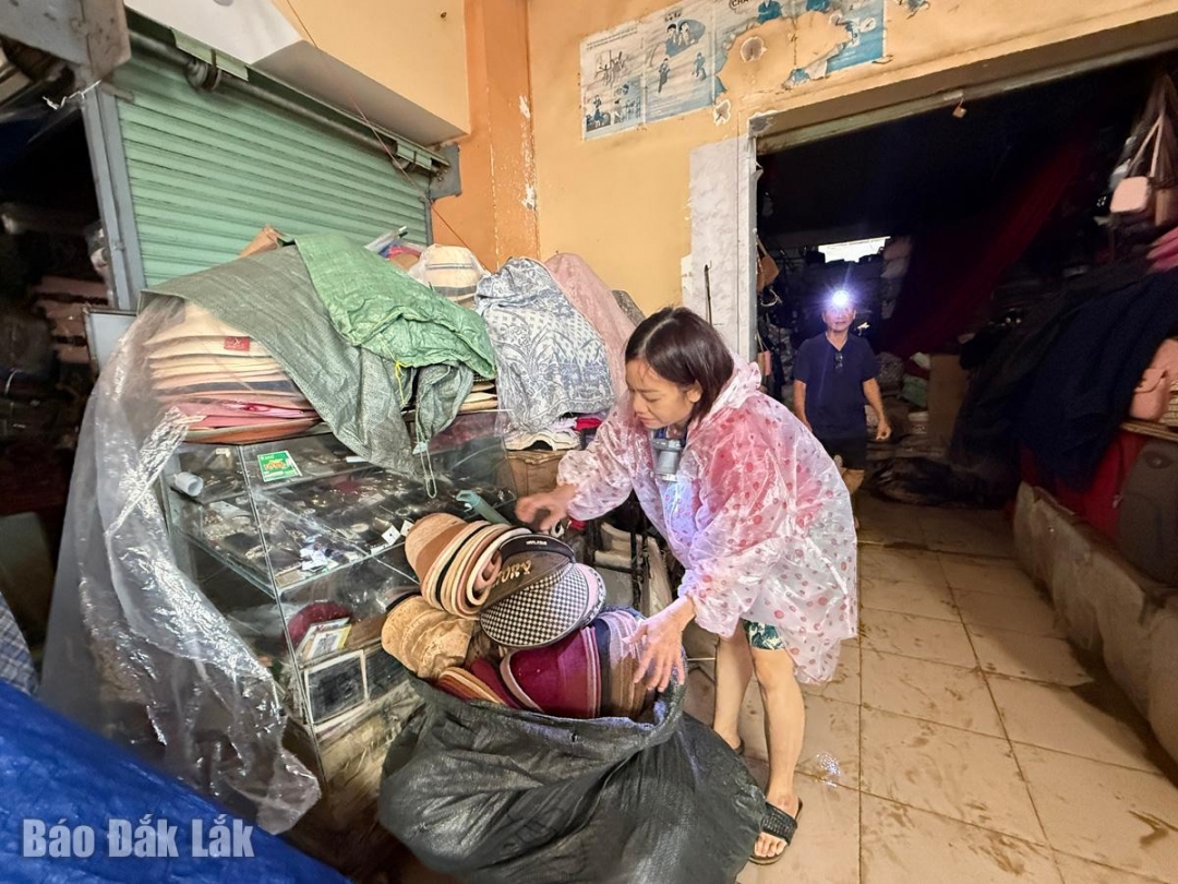 Chị Nguyễn Thị Nguyệt khóc ròng với gian hàng bị ngập hoàn toàn của mình, giờ không biết khắc phục từ đâu.