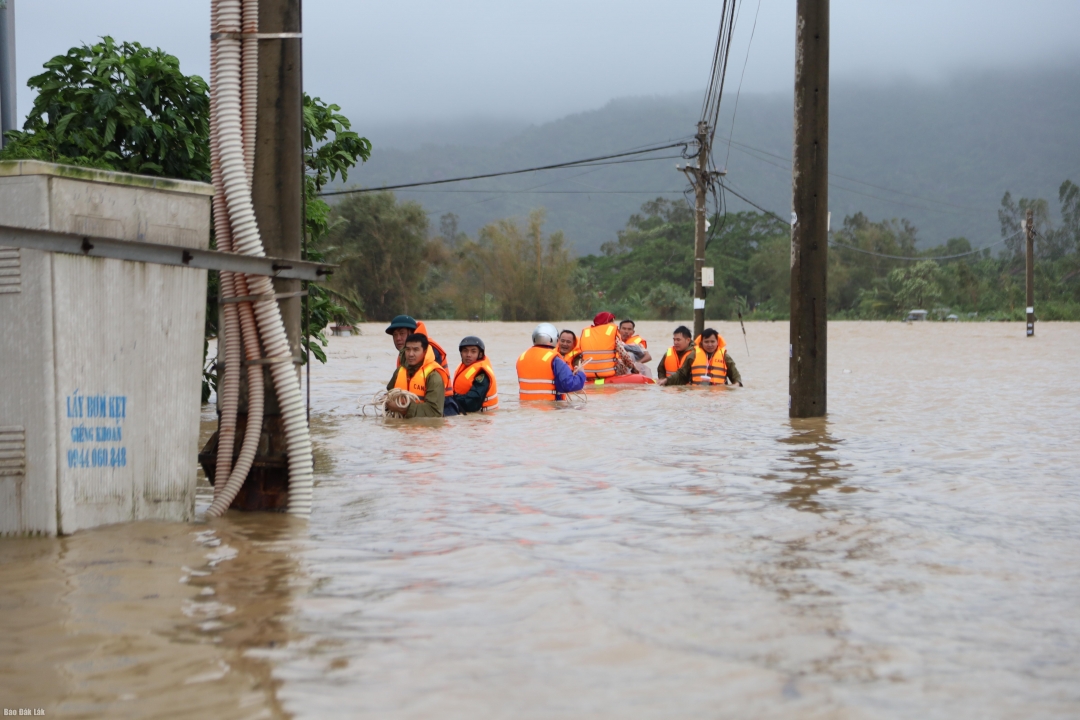 Lực lượng chức năng dầm mình trong nước lũ cứu người gặp nạn tại xã Hòa Xuân Đông.