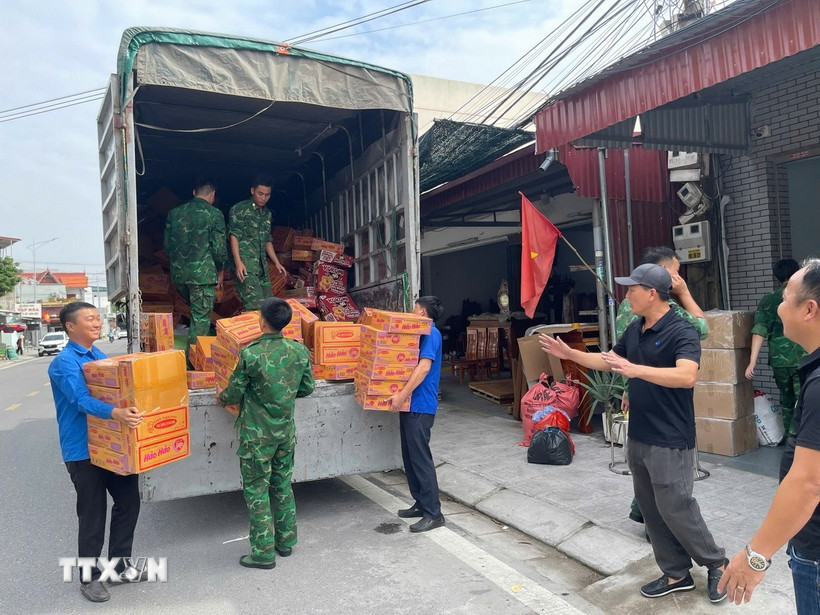 Các thùng mỳ tôm được vận chuyển lên xe ủng hộ người dân vùng lũ miền Trung. Ảnh: TTXVN