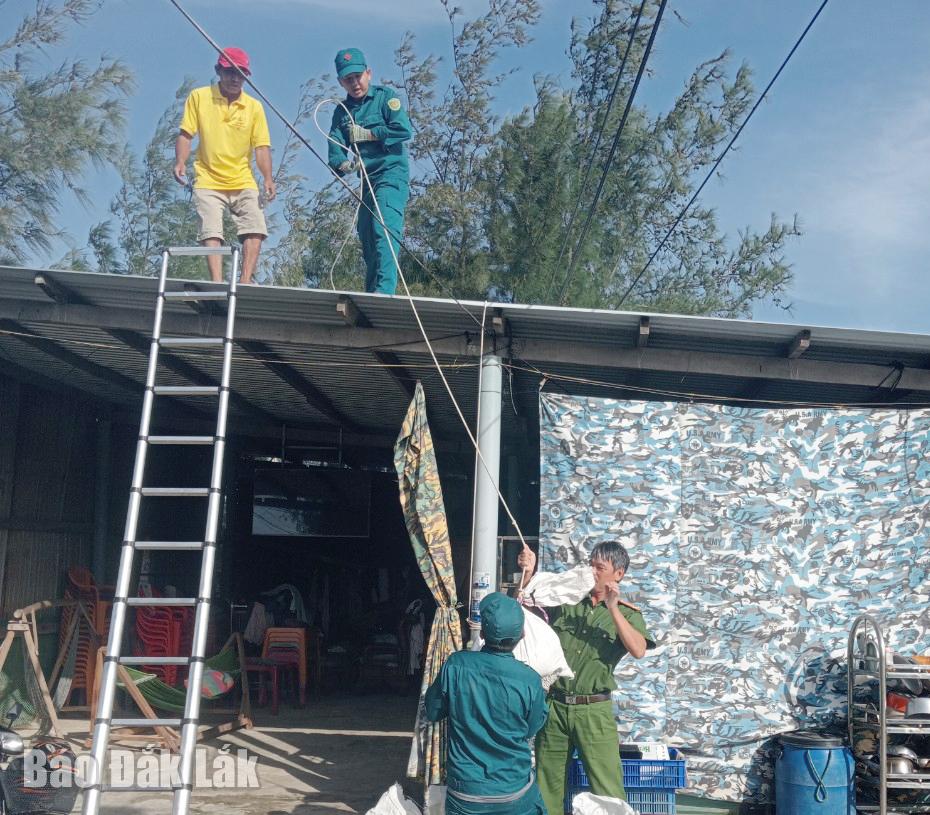 Các lực lượng chức năng xã Xuân Cảnh giúp người dân gia cố, chằng chống nhà cửa. Ảnh: CTV