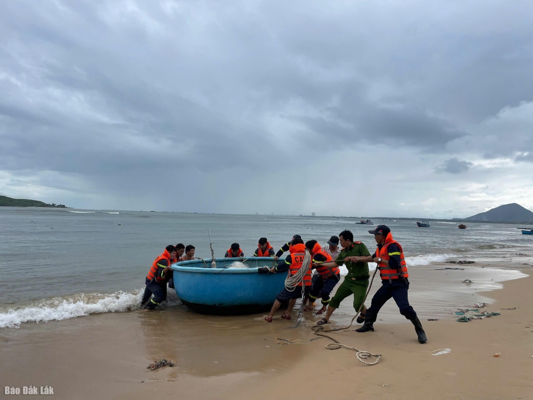 Lực lượng chức năng hỗ trợ người dân đưa thuyền lên bờ.