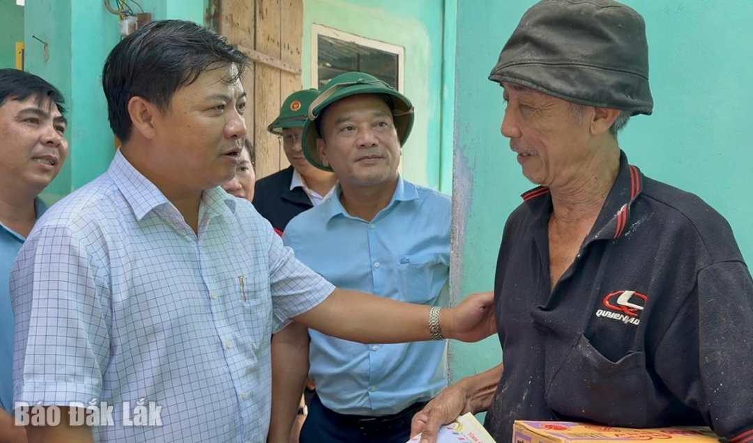 Đồng chí Lương Nguyễn Minh Triết động viên ông Nguyễn Văn Lang ở tổ dân phố Long Bình Đông (phường Sông Cầu) - nhà ông Lang bị tốc mái do bão số 13.