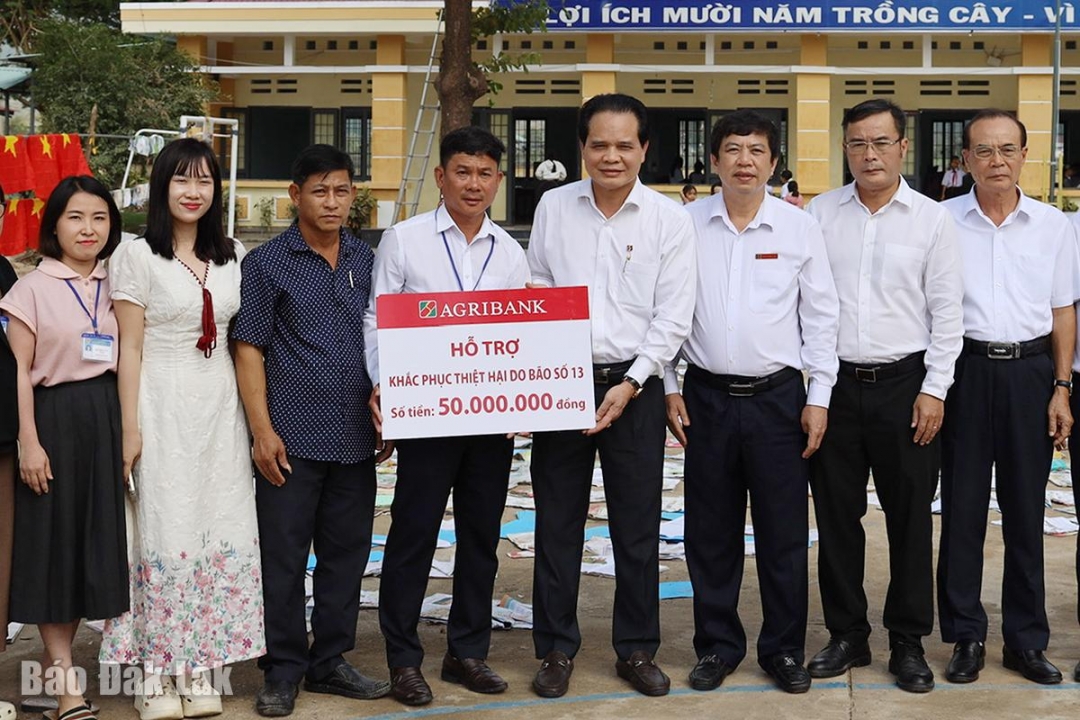 Phó Tổng Giám đốc Agribank Vương Hồng Lĩnh trao bảng tượng trưng hỗ trợ 50 triệu đồng cho Trường Tiểu học Phú Mỡ.