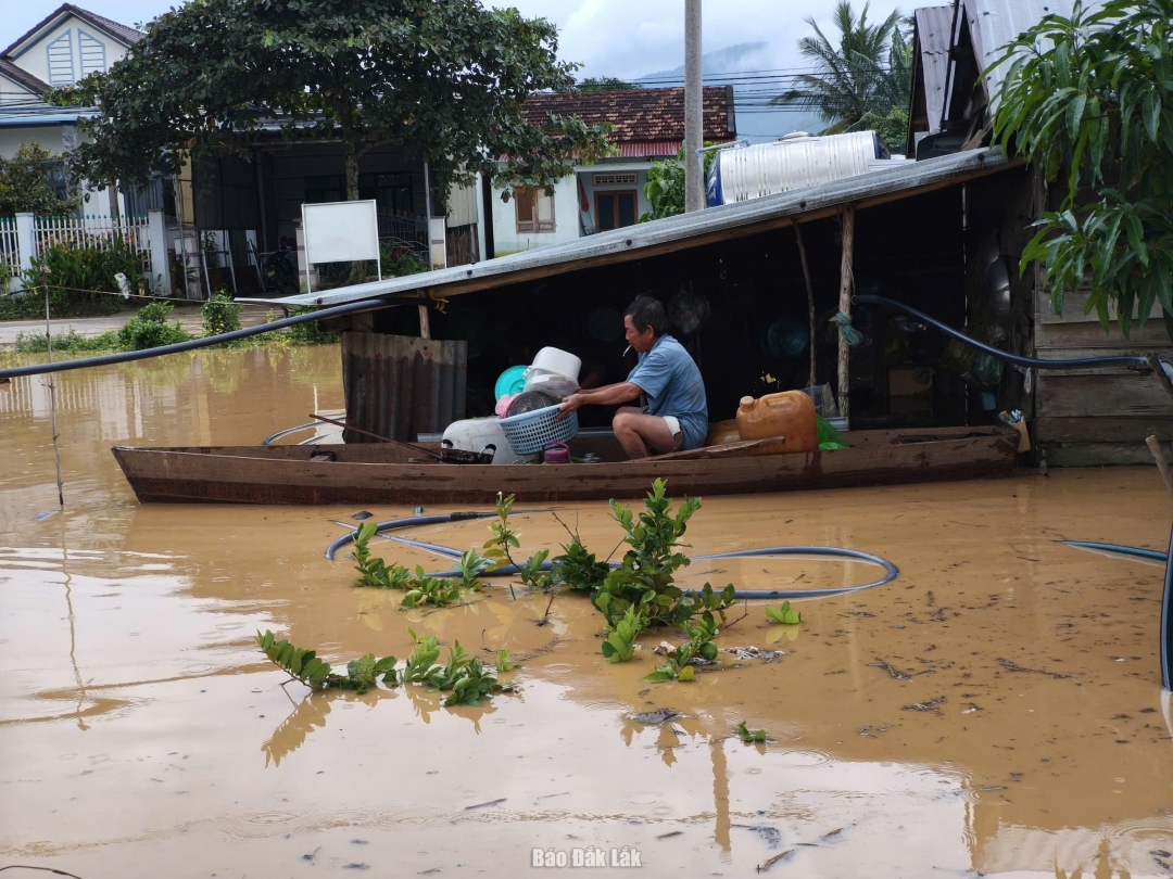 Một người dân cố gắng vớt vát ít vật dụng trong nhà khi lũ lên nhanh