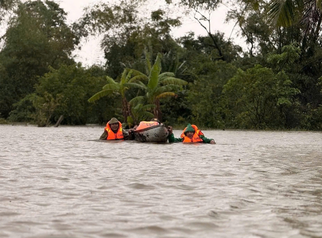 Lực lượng chức năng di dời người dân vùng bị ngập đến nơi an toàn (ảnh Công an tỉnh Đắk Lắk cung cấp)