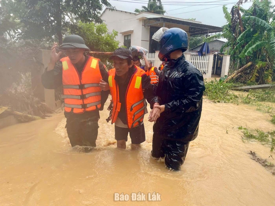 Lực lượng chức năng xã Hòa Mỹ hỗ trợ đưa người dân đến nơi an toàn. Ảnh: Thùy Thảo