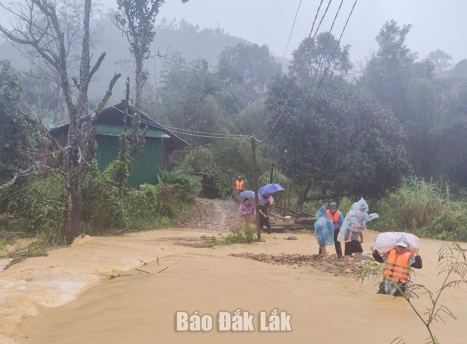 Lực lượng chức năng xã Cư Mta di chuyển người dân, tài sản tới nơi an toàn.