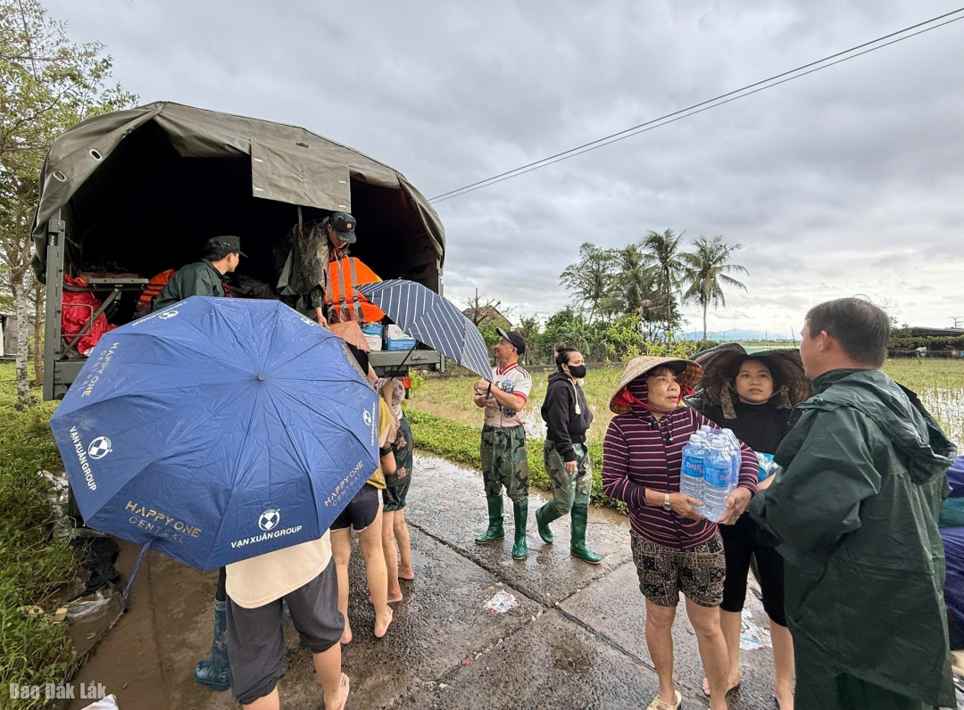 Các cán bộ, chiến sỹ Bộ chỉ huy quân sự tỉnh phát nước uống và nhu yêu phẩm cho người dân.