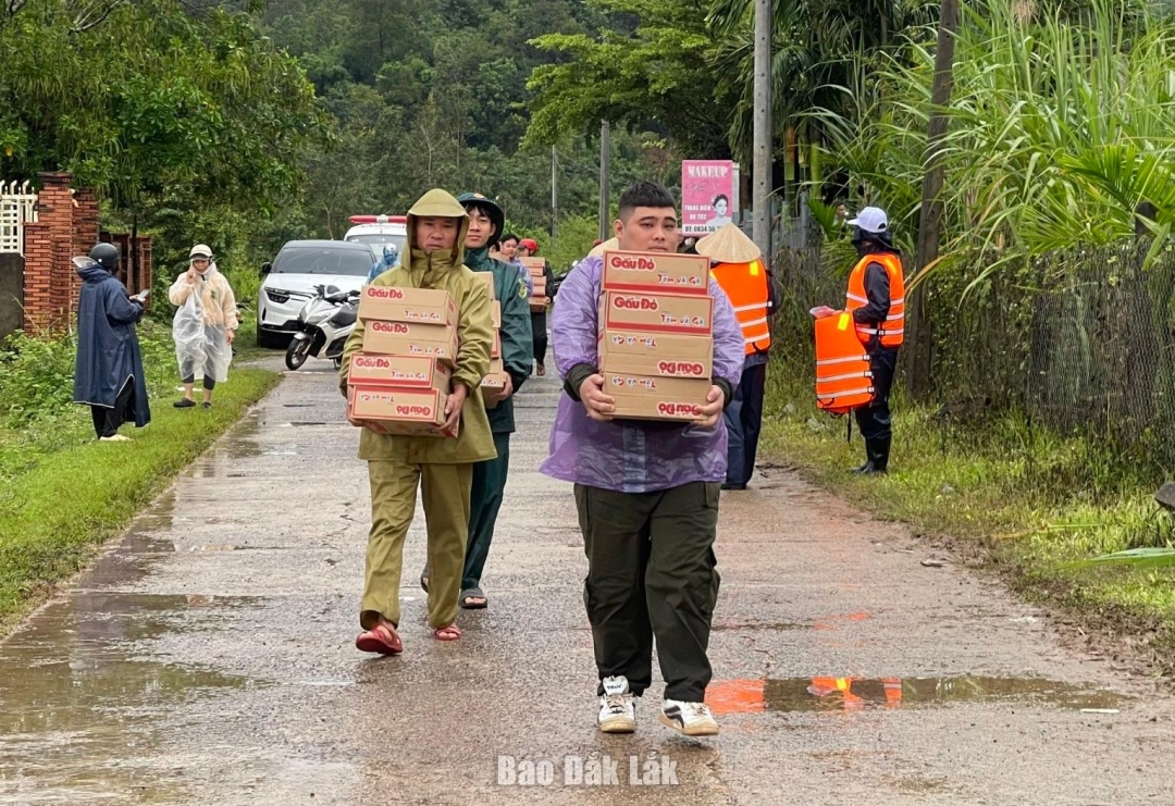 Lực lượng chức năng hỗ trợ nhu yếu phẩm cho người dân bị cô lập do mưa bão tại xã Dray Bhăng.