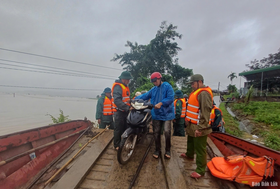 Lực lượng chức năng xã Krông Ana hỗ trợ người dân di chuyển bằng thuyền vì khu dân cư bị ngập nước.