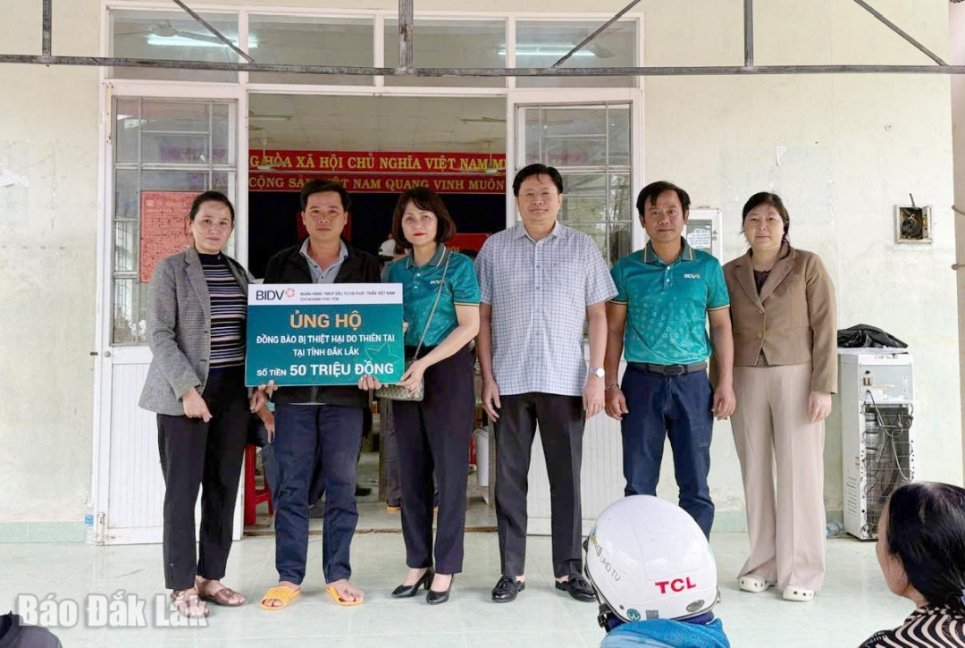 Ông Hoàng Linh, Phó Giám đốc Ngân hàng Nhà nước Chi nhánh khu vực 11 (thứ ba từ phải qua) và đại diện BIDV Chi nhánh Phú Yên trao bảng tượng trưng hỗ trợ 100 suất quà trị giá 50 triệu đồng cho người dân vùng lũ Tuy An Đông.