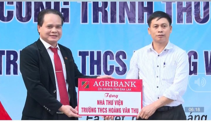 Ông Vương Hồng Lĩnh (bìa trái), Giám đốc Agribank Đắk Lắk trao biển tặng nhà thư viện cho Trường THCS Hoàng Văn Thụ (xã Ea kiết, huyện Cư Mgar).