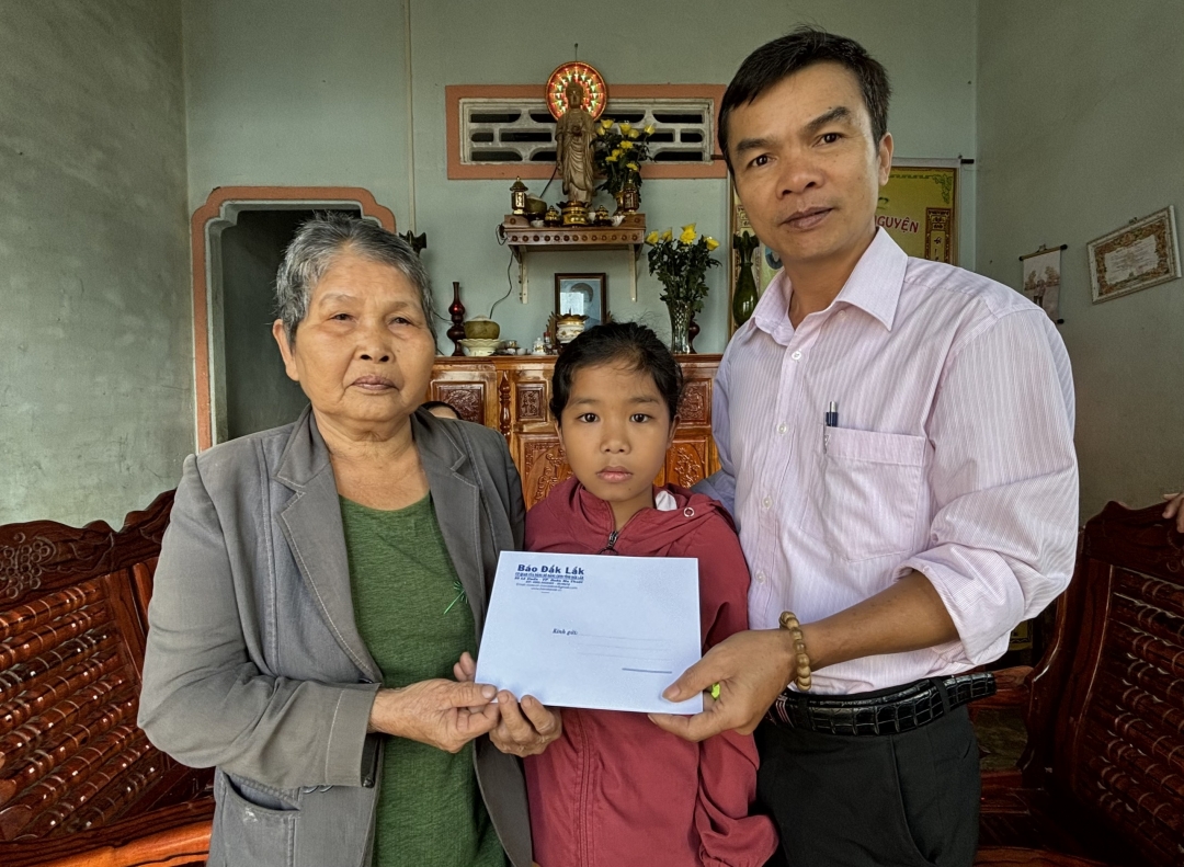 Đại diện Báo Đắk Lắk trao quà của Quỹ Tấm lòng vàng hỗ trợ gia đình cháu Nguyễn Thị Thảo. 
