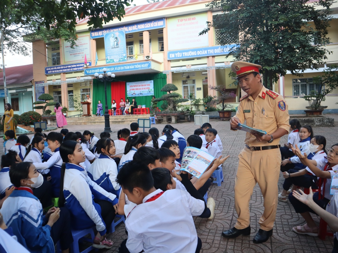 Cán bộ Đội Cảnh sát giao thông - Trật tự, Công an TP. Buôn Ma Thuột tuyên truyền an toàn giao thông cho học sinh tại Trường THCS Đoàn Thị Điểm.