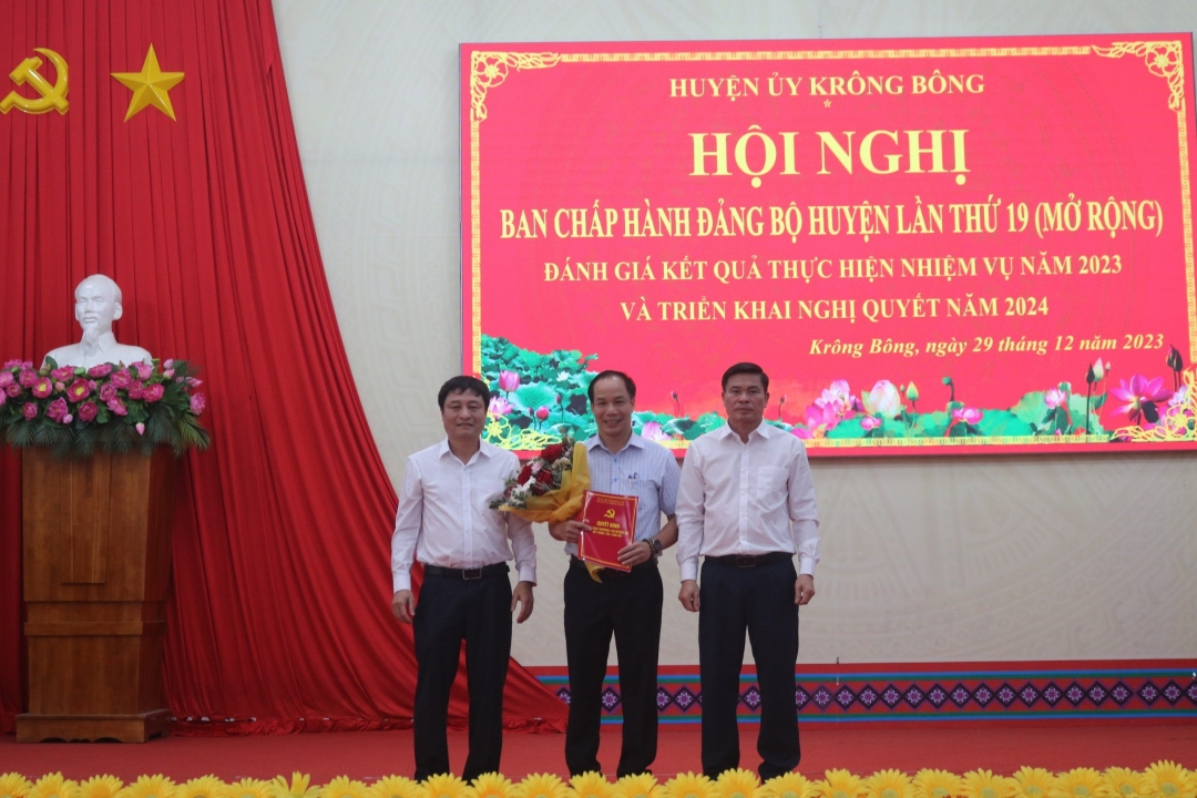Tỉnh ủy viên, Phó Chủ nhiệm thường trực UBKT Tỉnh ủy Hồ Duy Thành trao quyết định và đại điện lãnh đạo Huyện ủy Krông Bông tặng hoa chúc mừng đồng chí Vũ Xuân Triều.
