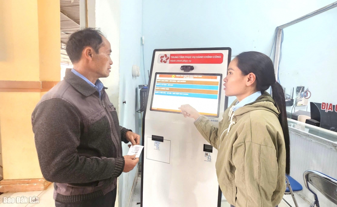 Cán bộ xã Yang Mao hướng dẫn người dân sử dụng máy bấm số thứ tự.