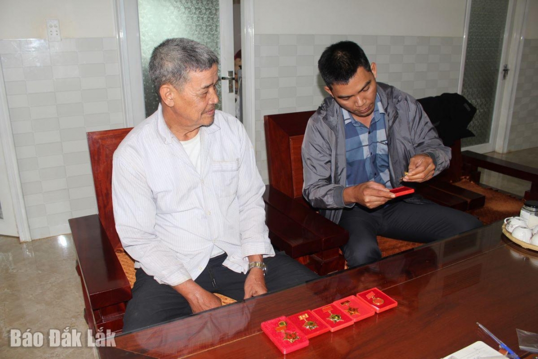 Cán bộ Phòng Văn hoá - xã hội (xã Ea Nuôl) xem những kỷ niểm chương trong các mặt công tác của Ae Thiêm