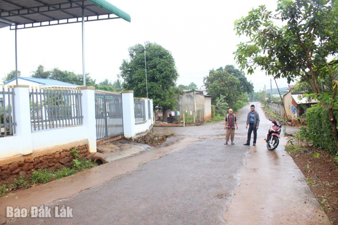 Ông Y Toan Niê cùng với cán bộ Phòng Văn hoá - xã hội xã Ea Nuôl trên những con đường mà trước đây ông đã vận động người dân hiến đất mở rộng đường. 