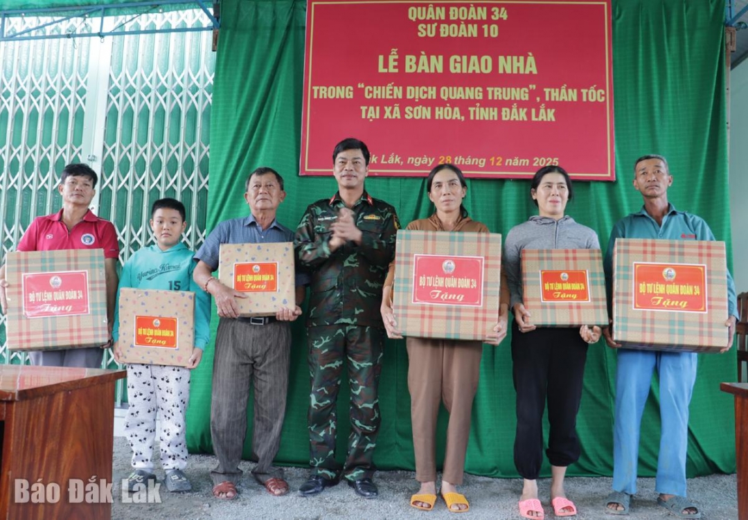 Thượng tá Đặng Thành Tuyên, Phó Chính ủy Sư đoàn 10 tặng quà cho các hộ dân về nhà mới. 