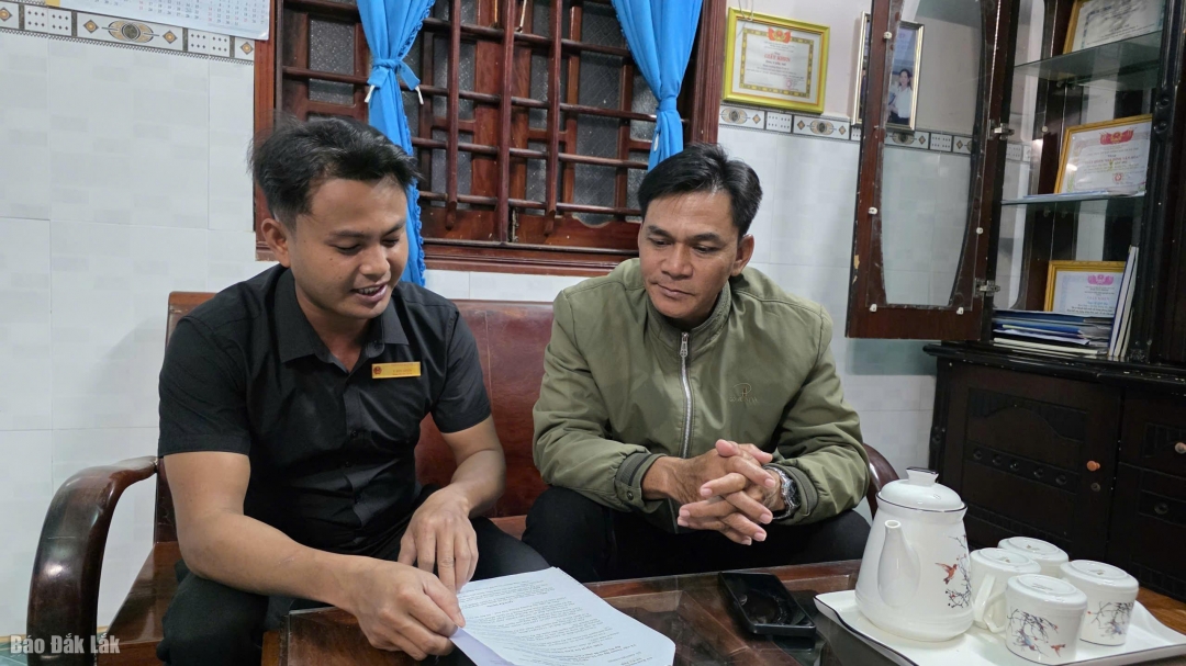 Ông Y Gôl Niê (bìa phải) thường xuyên tìm hiểu, cập nhật các văn bản, thông tin mới để triển khai kịp thời và phổ biến đến bà con.