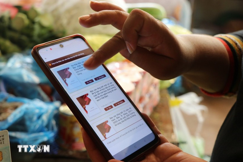 Người dân góp ý Dự thảo các Văn kiện trình Đại hội XIV của Đảng thông qua ứng dụng VNeID. Ảnh: TTXVN