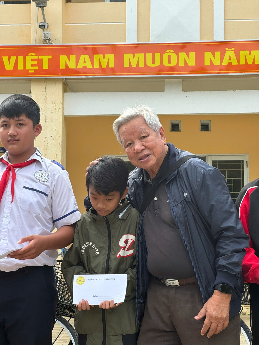 Ông Lê Văn Hữu, nguyên Chủ tịch UBND tỉnh Phú Yên tặng học bổng, động viên các cháu học sihnh vùng lũ xã Sơn Hòa.