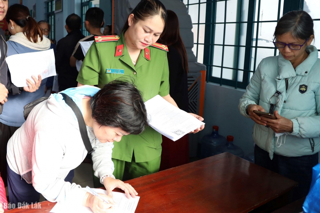 Cán bộ công an phường hướng dẫn người dân ký cam kết.