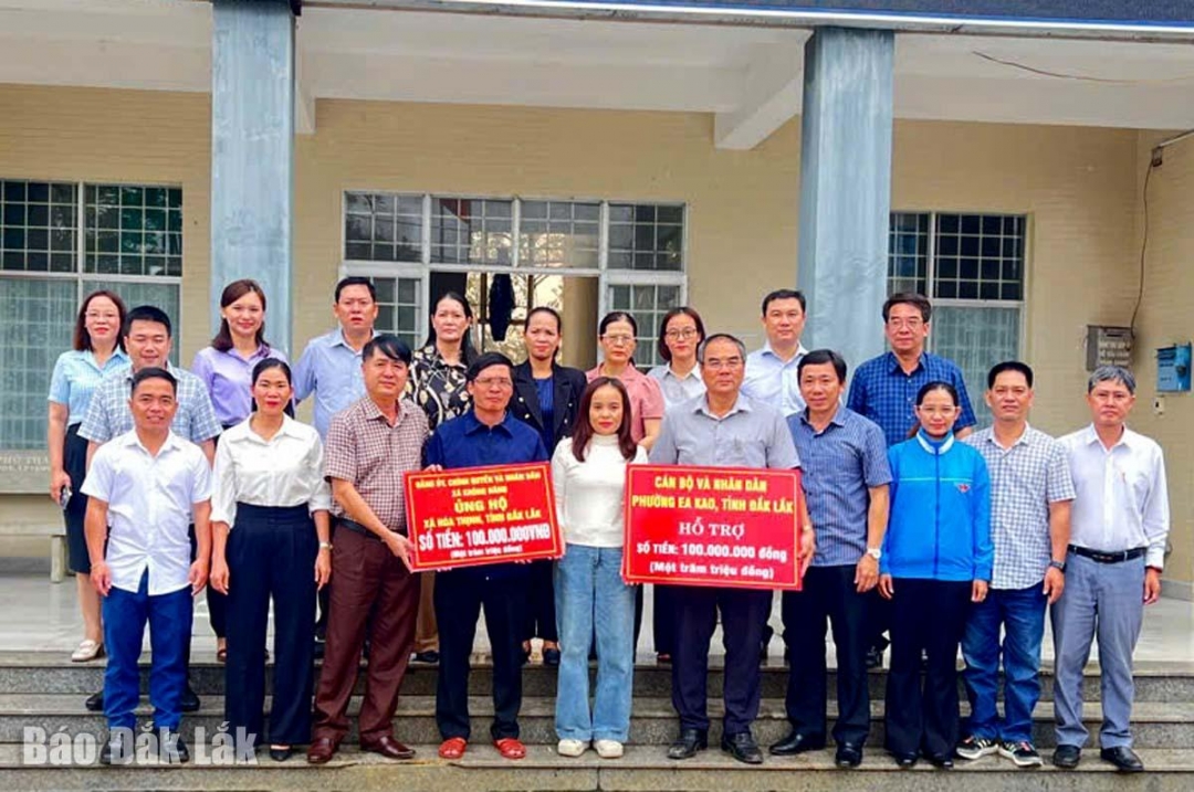 Lãnh đạo phường Ea Kao và xã Krông Năng trao bảng tượng trưng mỗi đơn vị 100 triệu đồng cho lãnh đạo xã Hòa Thịnh để giúp địa phương khắc phục sau mưa lũ. 