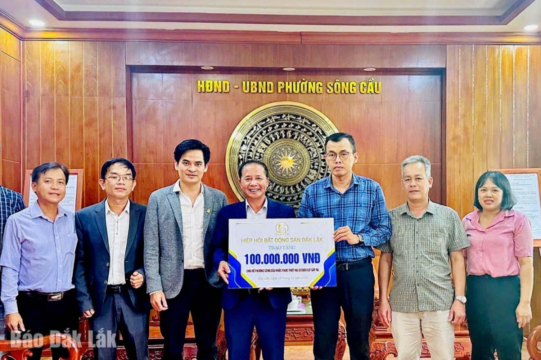 ông Trần Tiến Lợi (giữa), Chủ tịch Hiệp hội Bất động sản Đắk Lắk trao bảng tượng trưng 100 triệu đồng cho lãnh đạo phường Sông Cầu để khắc phục hậu quả mưa lũ