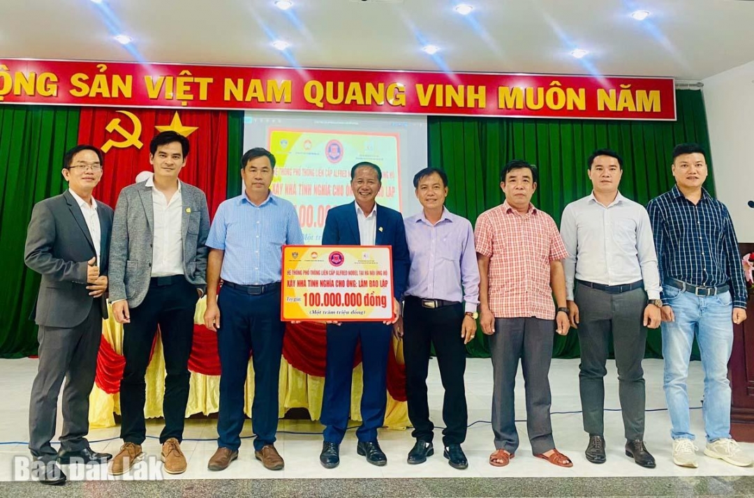 ông Trần Tiến Lợi (thứ 4 từ trái qua), Chủ tịch Hiệp hội Bất động sản Đắk Lắk đại diện hệ thống phổ thông liên cấp Alfred Nobel (Hà Nội) trao 100 triệu đồng cho xã Xuân Lộc để xây dựng nhà tình nghĩa cho gia đình ông Lâm Bảo Lập