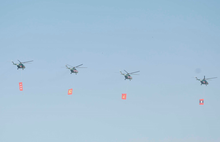 Biên đội máy bay trực thăng mang cờ bay trên bầu trời khu vực tổ chức lễ kỷ niệm. Ảnh: TTXVN