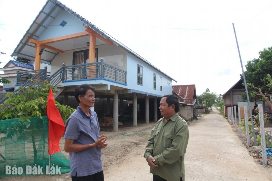 Bí thư Chi bộ buôn Jun Y Rôn Bkrông (bên trái) tuyên truyền, vận động người dân về công tác xóa đói giảm nghèo, phát triển kinh tế gia đình. 