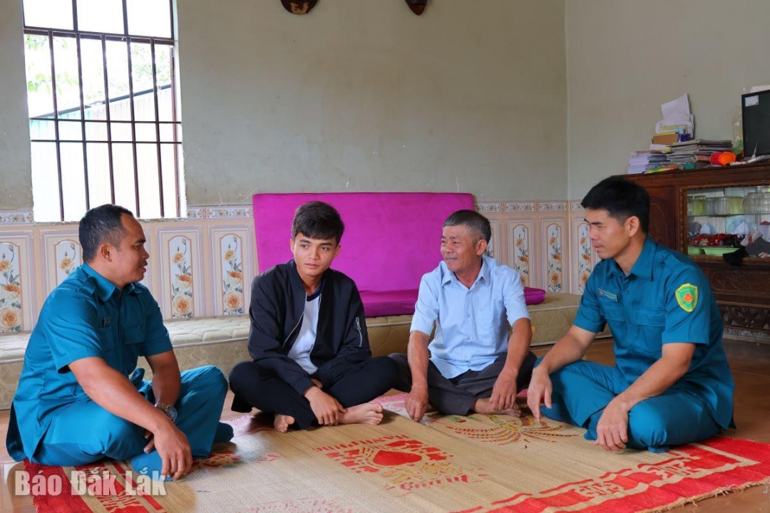 Người uu tín cùng cán bộ Ban Chỉ huy Quân sự xã chuyện trò, động viên công dân thực hiện tốt nghĩa vụ quân sự.