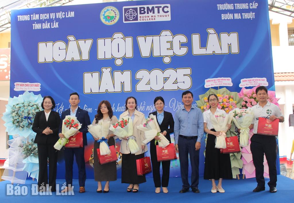 Lãnh đạo Trung tâm Dịch vụ việc làm tỉnh và Trường Trung cấp Buôn Ma Thuột tặng hoa, quà cho các doanh nghiệp tham gia tuyển dụng tại ngày hội.
