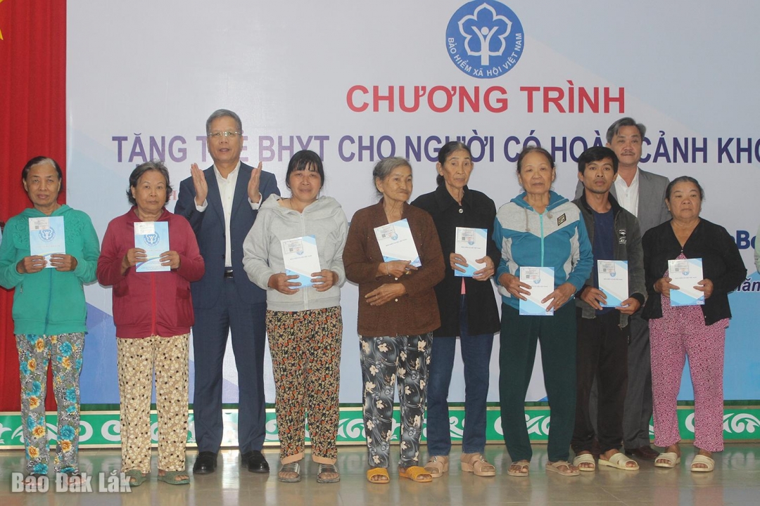 Phó Giám đốc Bảo hiểm xã hội Việt Nam Trần Đình Liệu và ông Nguyễn Hữu Từ, Phó Bí thư chuyên trách Đảng ủy UBND tỉnh trao tặng thẻ bảo hiểm y tế cho người dân xã Phú Hòa 2.