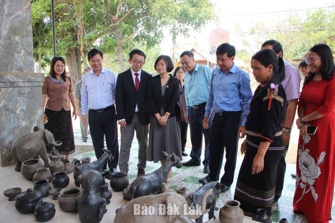 Người dân buôn Dơng Bắk giới thiệu sản phẩm gốm truyền thống đến du khách.